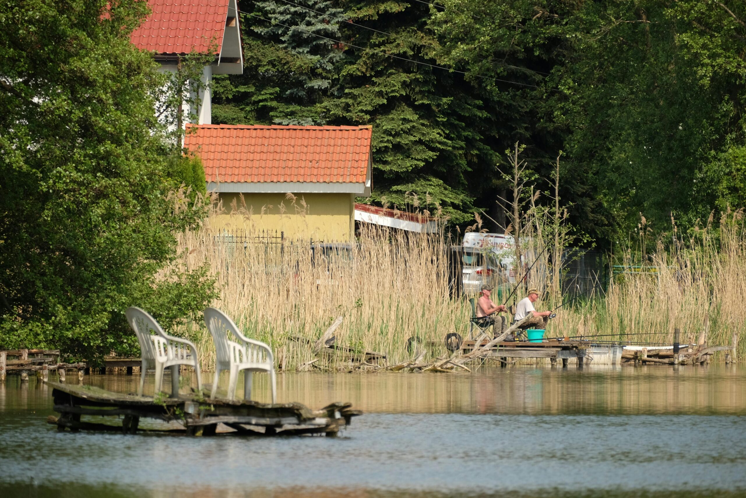 A lake with a house and a boat in the background